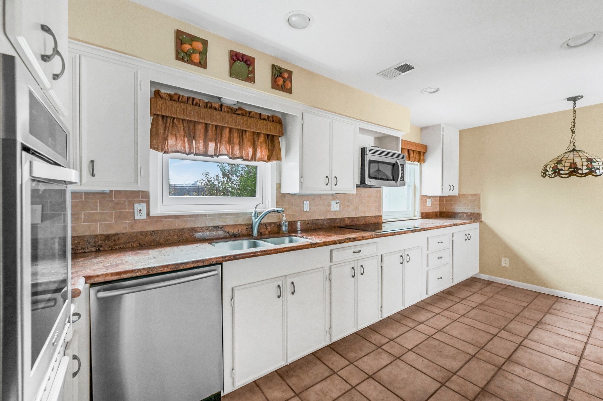KITCHEN HAS BEEN UPDATED WITH GRANITE COUNTERS AND STAINLESS STEEL APPLIANCES, PLUS ELECTRIC COOKTOP.