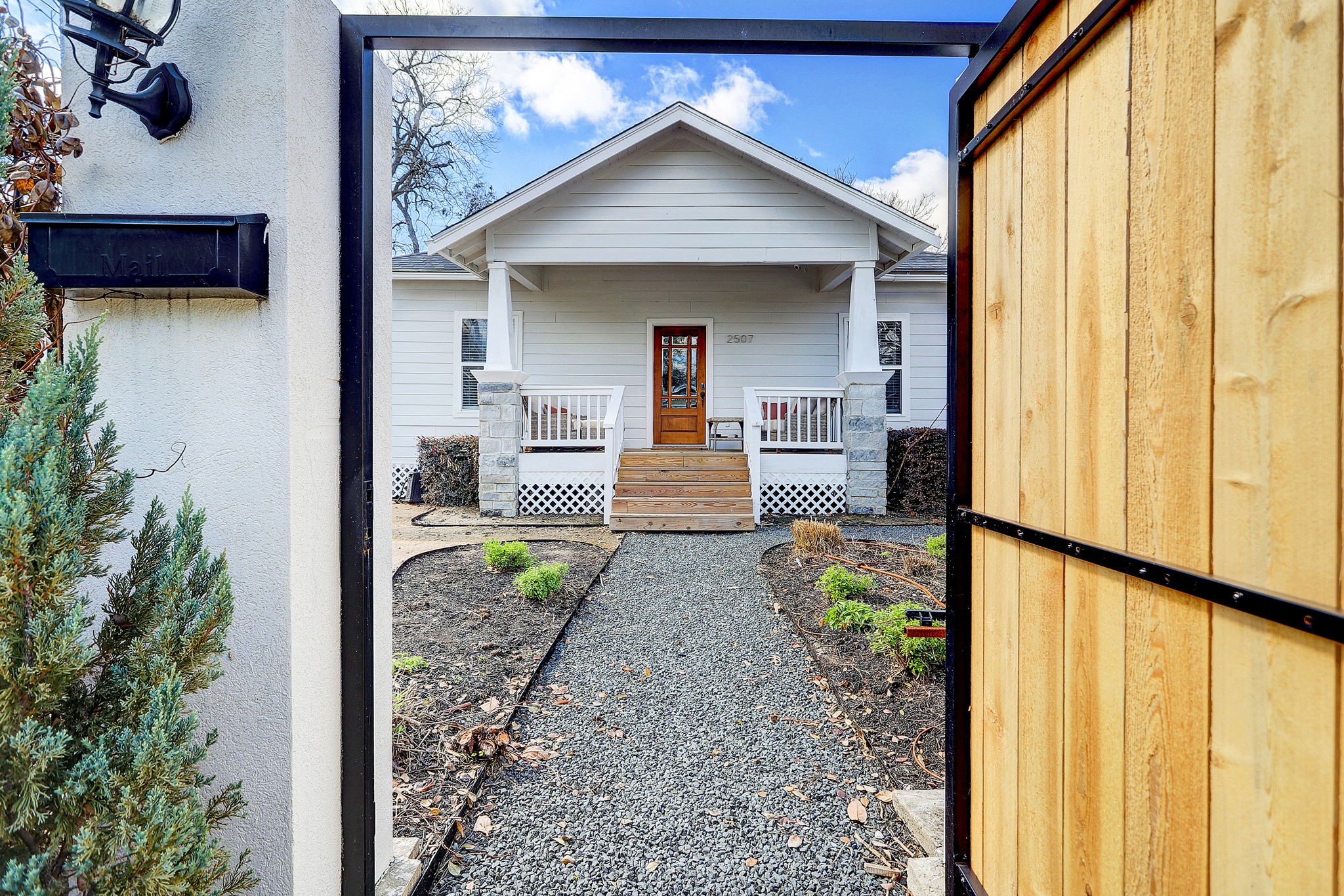 2507 Everett is seated behind a privacy fence, custom steel pedestrian gate, and automatic driveway gate.