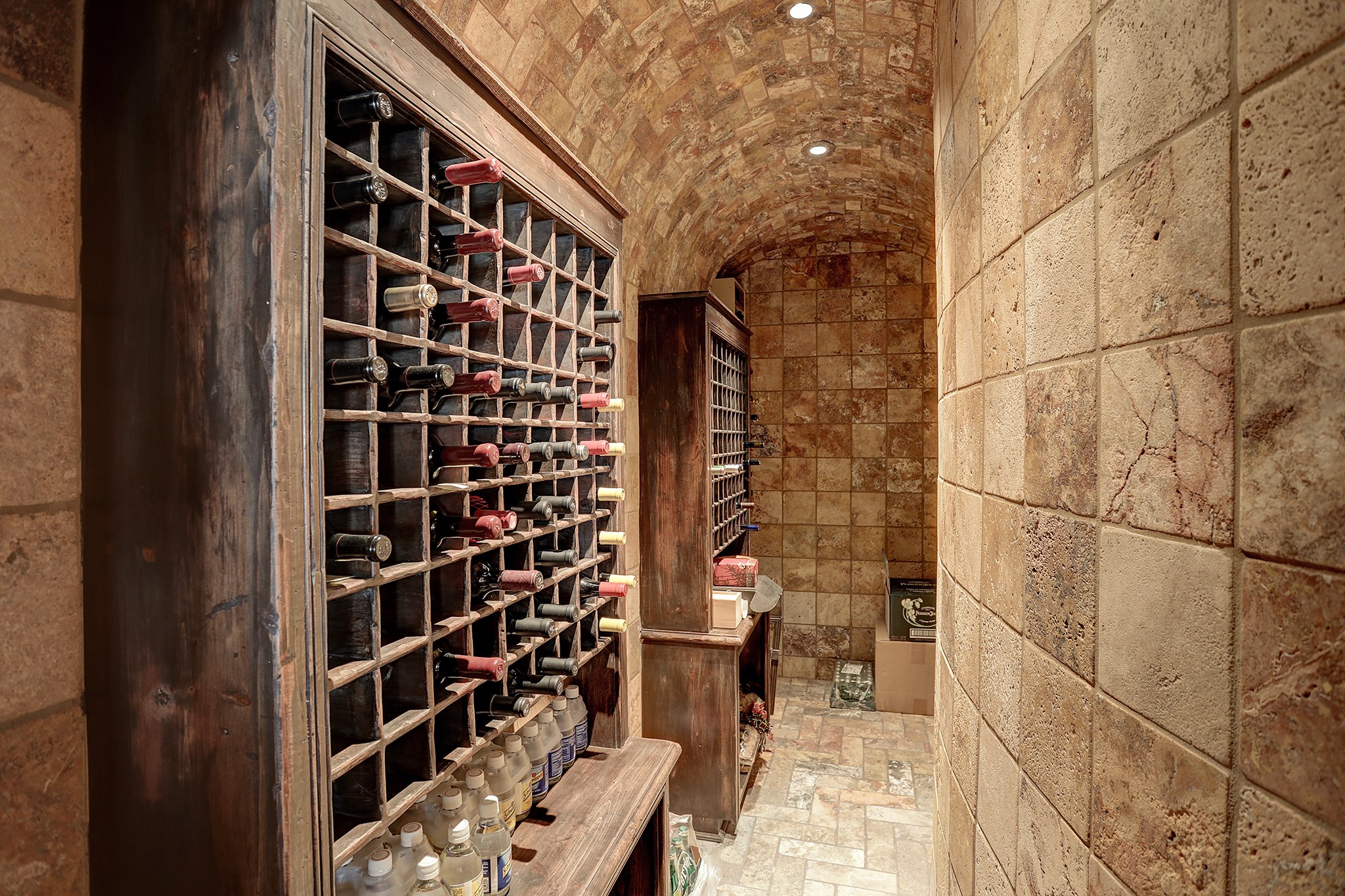 The Wine Vault is temperature controlled with honed travertine tile floor, walls and barrel ceiling.  At present there is a minimum of 200 bottle capacity (more could be added to the built-in cabinets).