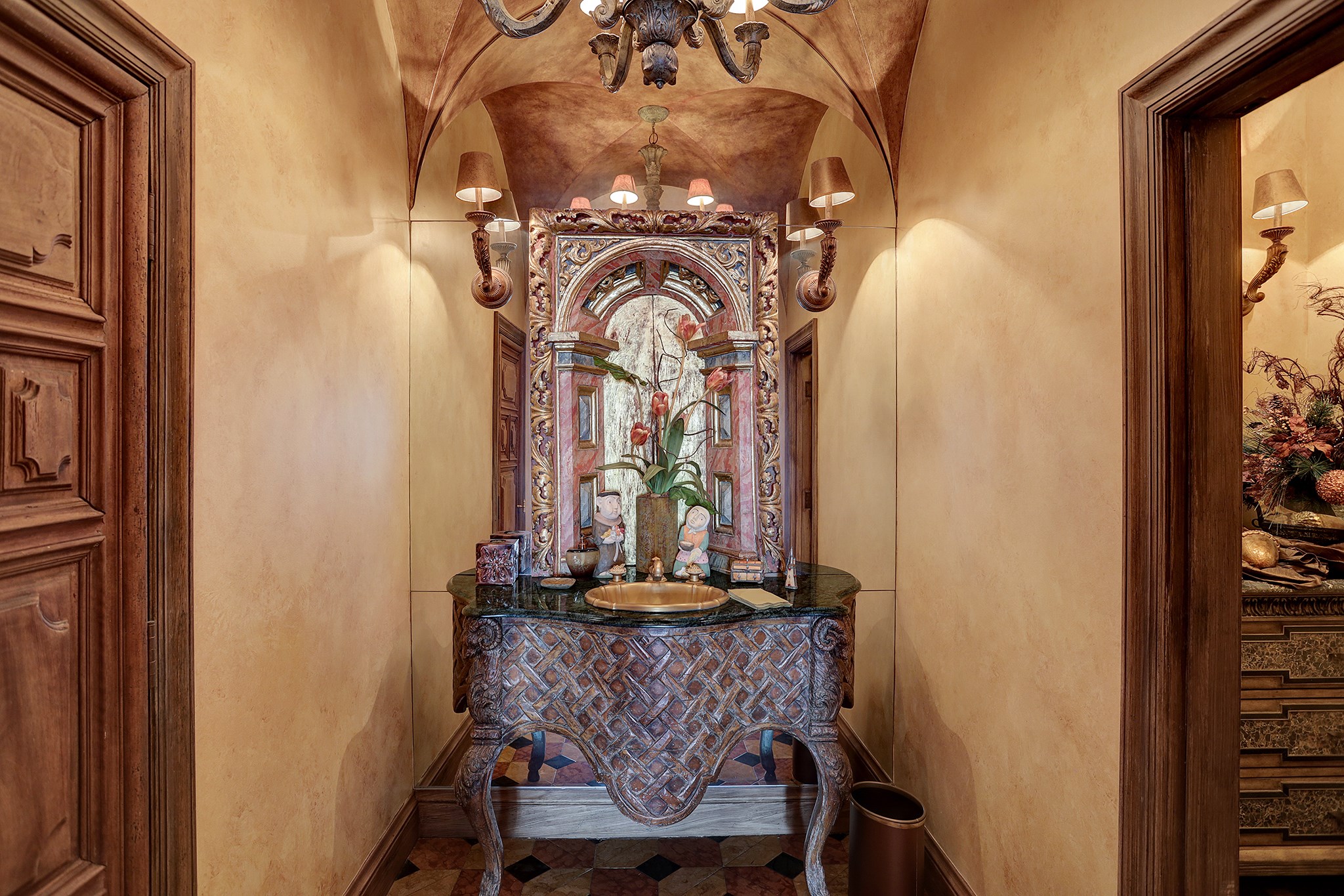 The Formal Powder Room is located off of the Foyer.  This is a photo of the Ante Room with variegated travertine tile floor with stone inlay and an antique console table with cabriole legs, granite deck and fluted sink.