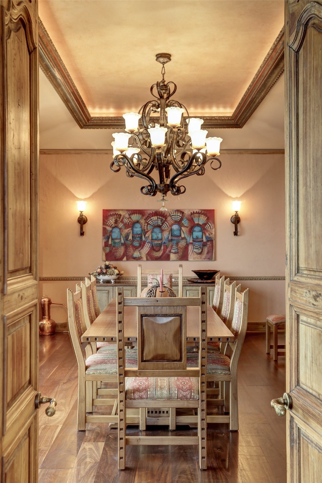 A pair of antique wooden doors open from the Living room into the formal Dinning room.  There is a recessed, faux gilt ceiling in a baroque frame.