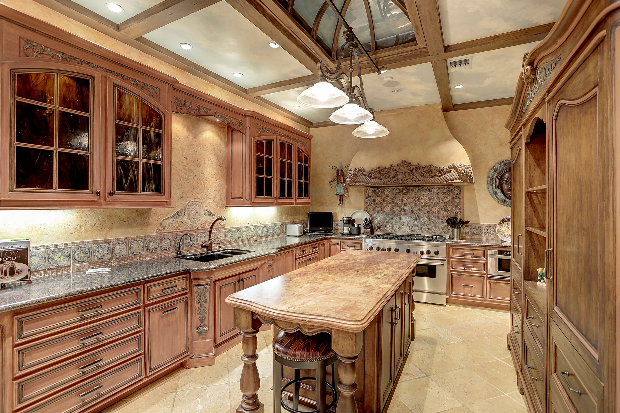 The Kitchen boasts Venetian plaster walls, buffed / honed travertine tile floors, armoire-style cabinet for refrigerator and freezer + refrigerator and freezer drawers and a Thermador range with custom hood with 