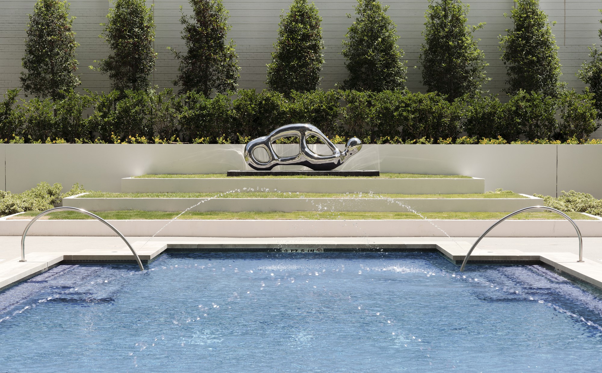 Tiered landscaping and a stunning sculpture are the backdrop for the lap pool.
