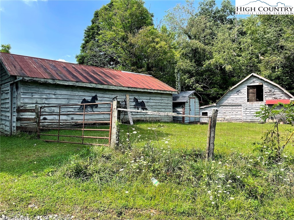 Over 3 acres in the Todd Community, with 2 Single -Wides, 2 Barn and  outbuilding. Gently laying land, with mostly open meadow, , room for animals and crop land as well. Property has road frontage on Milt Houck Road, but is accessed by a 10ft right of way off gravel road. Shared well between the 2 single wides. One single wide is vacant, and other is rented by a caretaker who does not pay rent in lieu of taking care of the property. Each Single wide is a 3BR/2BA. Property would be an ideal rental property or remove single wides and create your own mini-farm. See today