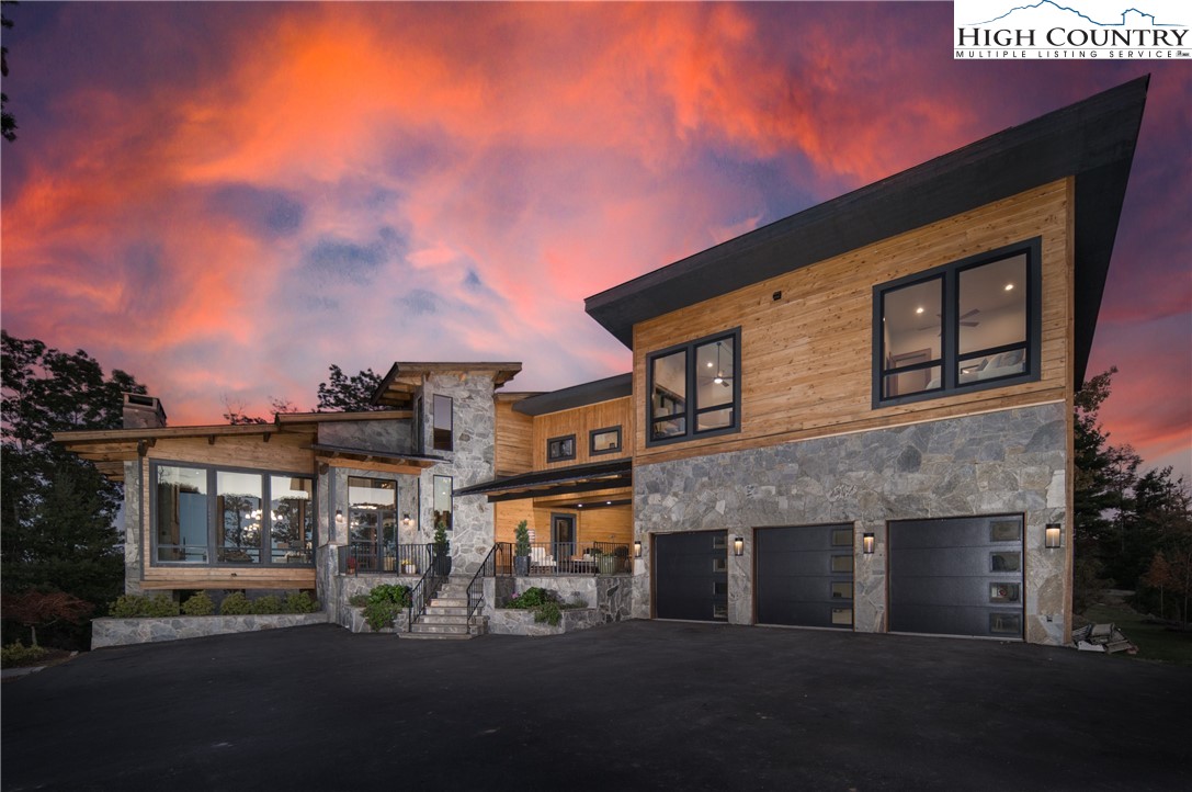 This stunning three level, timber frame, modern mountain home in Blue Ridge Mountain Club will take your breath away! The builder’s personal residence, it sits on a private knoll with over 3.6 acres where you can enjoy both sunrise and sunset views from the dramatic walls of glass in the double height great room. The main level primary suite leads to its own deck, and the glass walled wine room and wet bar are additional highlights of this level. The large chef’s kitchen offers high end appliances and a huge island for entertaining. Upstairs you will find two more living areas as well as a day kitchen and additional bedrooms with custom built in beds. Downstairs you will find a comfortable family room with auxiliary kitchen that leads to a stone patio with fireplace and more spectacular views. Four living areas, and  approximately 1500 s/f of covered outdoor living space plus the flat grassy yard offer a multitude of options for entertaining. Some of the high end features of this home include teak floors, Hubbarton Forge light fixtures, upgraded windows, cypress siding, and elevator prep. Take your mountain living experience to the next level with this amazing home!
