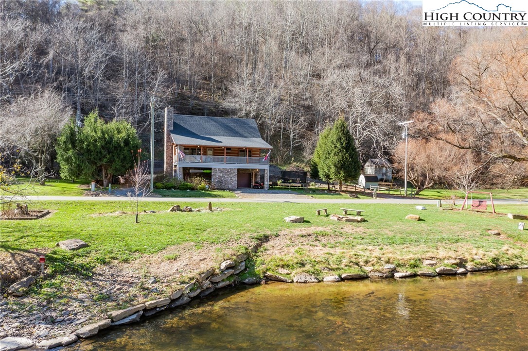 Are you dreaming of a Mountain getaway? This riverfront retreat is move-in ready. Stunning craftsmanship in this log mountain home with your own river access to the New River. This charming home has a welcoming open floor plan, impressive construction, attention to detail, quality, and comfort. There is plenty of room with three beds, three full baths, a loft, and a fully finished walkout basement with a bathroom and kitchen. The primary bedroom with stunning views has a spa-like bathroom. The entertainment-friendly main-level kitchen has a new island with a modern backsplash. Rent the finished "studio" (currently set up as a gym) basement with a separate entrance. Get into your kayak from the cobblestone launch. Fly fish from your front step. The riverbank is protected from the river's current with a rock J hook. From the rock steps, step comfortably into and out of the river. Enjoy the large deck overlooking the river after a day of fun! Makes some smores on the riverbank firepit in the evening. Enjoy everything the Mountains in the High Country have to offer year-round. No HOA. Long-term and short-term rentals are allowed!