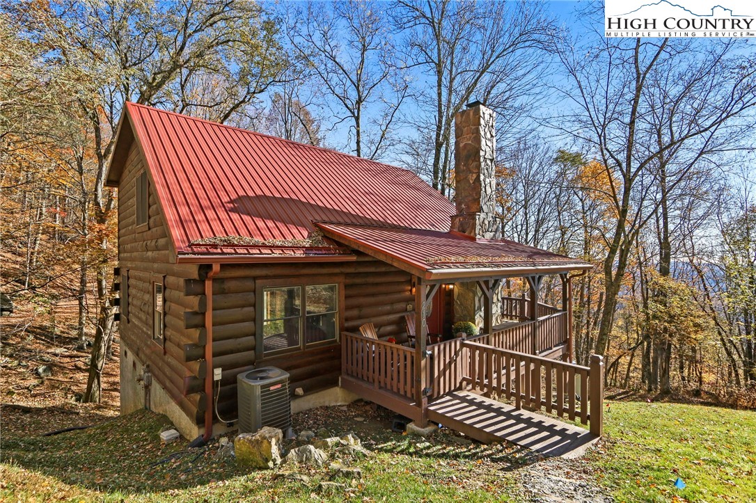 Outstanding cabin sitting at 4,000 feet elevation with seasonal views of Grandfather Mountain and adjoining North Carolina Protected Lands (Bear Paw State Park / Lands).  A perfect cabin with great privacy, encompassed by nature and ready to be enjoyed during those snowy nights by the stone fireplace.  This cabin would make a great rental investment and is being sold furnished, has 3 physical bedrooms setup, with a 2 bedroom septic - ( 2beds on the main level and one upstairs w/ ensuite and no closet.)  Other features include cathedral ceiling in the main rooms of the first floor, stone fireplace with gas logs, open kitchen with granite tops, wood and tile flooring throughout, covered front entry with wrap around decking, and large windows for great natural light.  Extra details include metal roof, recent exterior staining, newer gutters, recent interior painting, twig railing to the upstairs and central A/C.   An exciting setting located in Seven Devils which offers residents a community center with a meeting space, kitchen, fitness room and more.  Seven Devils also has tennis and pickle ball, plus Hawksnest Snowtubing and Zipline Adventure is only 5 minutes away.