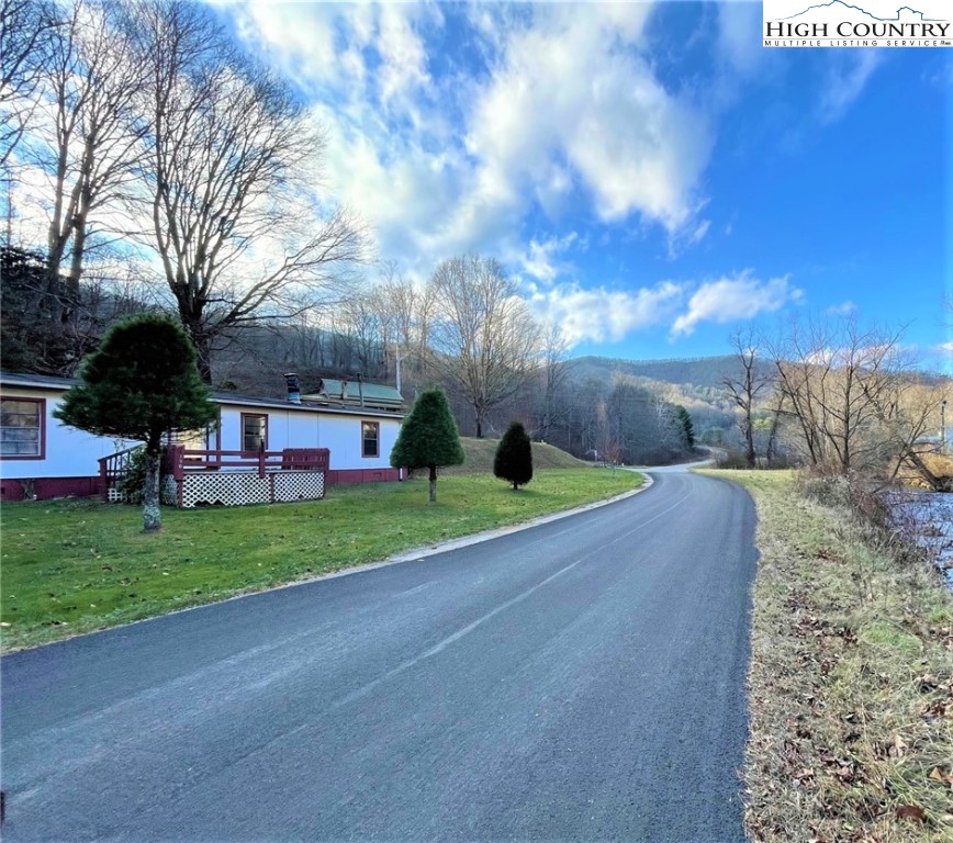 This 13+ Acres within 3 miles of Down Town West Jefferson NC has over 800 feet of City Maintained Paved Road Frontage. This unrestricted property has numerous possibilities. The doublewide home on the property does have active heat and electricity, but the owners count it as having no value. There are also two other buildings along with other older buildings and some car/truck parts that will stay on the property. The value is in the unrestricted land and where the land is located in relation to West Jefferson. Nice views of Buffalo creek can be seen from the property. The property has old roads cut into the hillside going to the summit of the property which has long-range views of the surrounding mountains. If you are looking for an investment property this one has very good potential! Priced to sell this one won't last long.