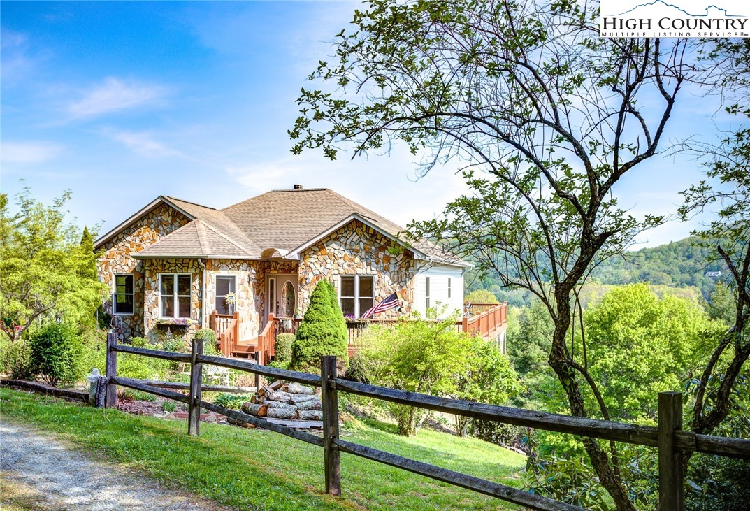 Big views in Boone, NC! Presenting an exceptional home on 3.5 usable acres, boasting breathtaking long range views! Enter to the foyer that opens up to an open kitchen with granite counters, light-filled dining area, and living area with stone wood burning fireplace. Wood floors throughout the first floor. The main level offers a serene primary suite, along with two bedrooms and a full bath. Walk out to the large upper deck from the living room and the primary suite. The lower level provides a spacious game and living room, opening to a large covered deck, ideal for entertainment. This level also offers another bedroom, full bath and laundry room. Outside, enjoy the front cottage garden, bursting with vibrant perennial flowers! The cleared grass area in the backyard offers a perfect play space for pets or outdoor activities. Brand new four bedroom septic system, and heat pump was replaced in 2022. This terrific home is located at the top of the Holiday Hills neighborhood, and is 1 mile from Samaritan’s Purse, 3 miles to the Watauga Medical Center and 2.5 miles to Boone Golf course. Downtown Boone is just 10 minutes away, 15 minutes to downtown Blowing Rock. See 3-D tour.