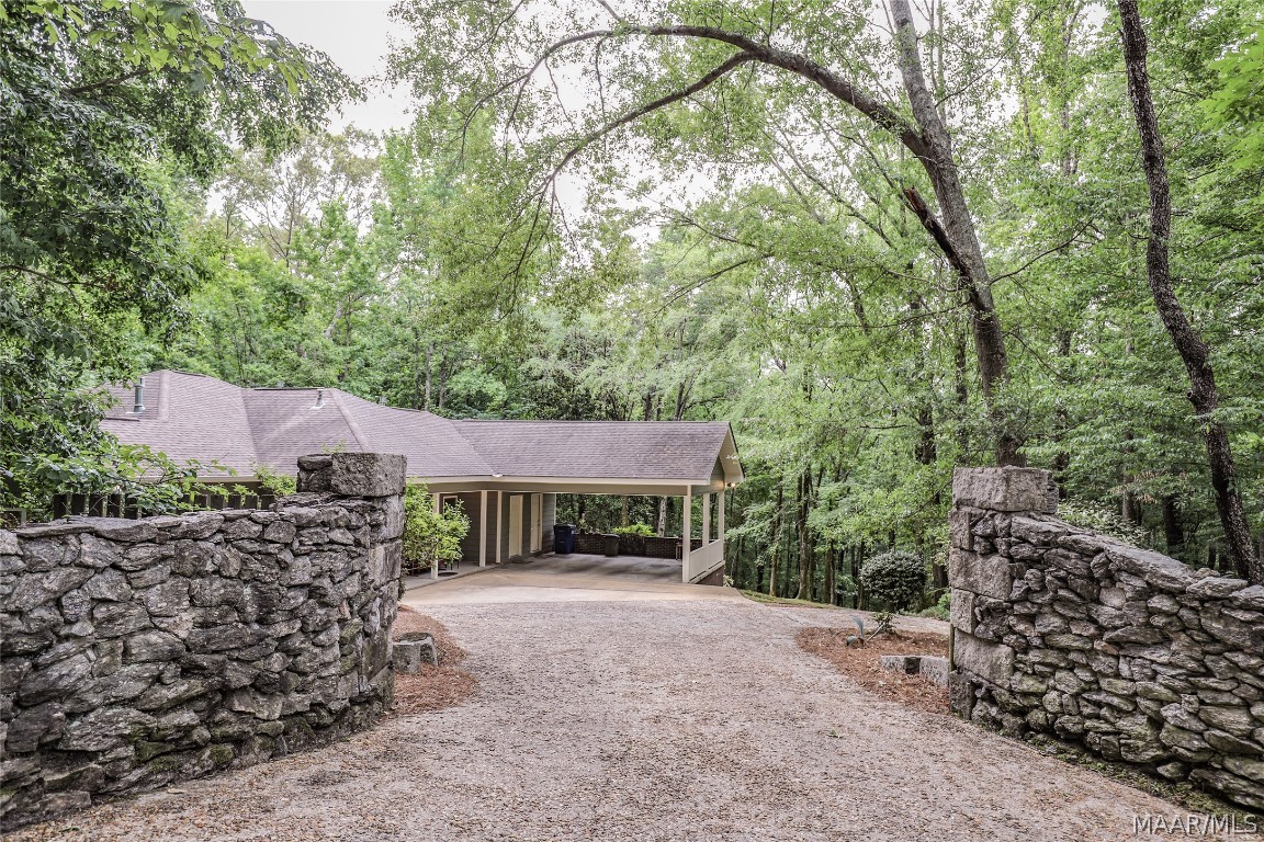 Welcome to this completely remodeled 3 bedroom home in the highly desired Indian Hills area of Wetumpka, AL. Drive through the rock gate to the large wooded lot.  Park in the carport and enter the door straight into this open space with a fabulous view of the forest beyond. The reading nook/game area is on the left and the family room is on the other side of the see through double sided gas fireplace. This spacious room is large enough for your sectional sofa and more. The kitchen and dining areas are wide open and share the view of the family room and the forest. New black, stainless steel appliances (4 years) in the kitchen, granite counter tops, really nice work island with seating. 40 feet of deck space for entertaining or just enjoying the sounds of the CREEK below. The master suite is on this main level. Luxurious master bedroom and bathroom with tile shower, granite vanity, and double closets. There is a half bath and oversized laundry room with storage space on this level. **Downstairs features 2 bedrooms, full bath, study/craft room, safe room, and a great room/ playroom/ entertaining space that opens to the lower patio.  Follow the patio to the right for more outdoor entertaining spaces and gazebo.  Man, the parties you could have here.