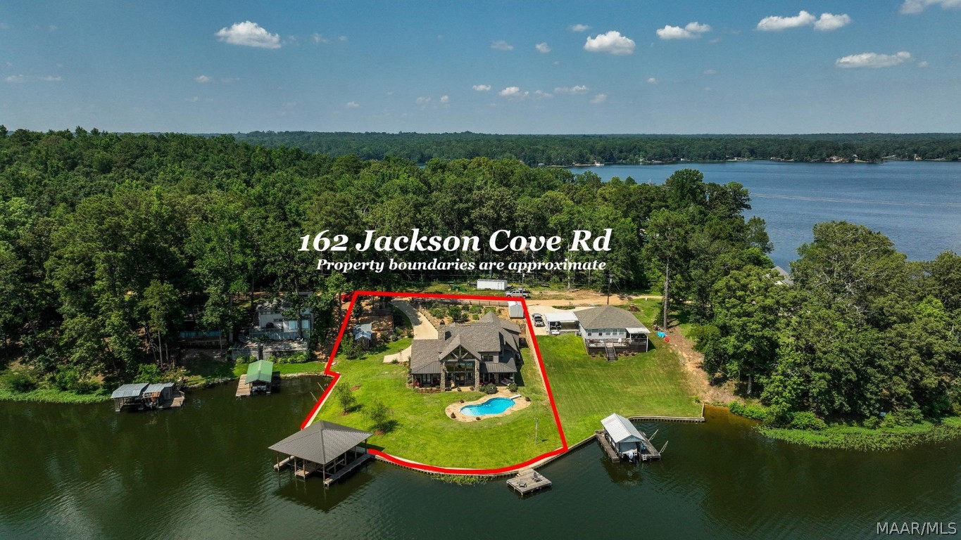 Are you looking for the BEST that Lake Jordan has to offer?  This is THE ONE! Custom built home completed in 2018 sitting on a flat lot w/ almost 300 ft of water frontage wrapped by a vinyl lighted seawall with a concrete sidewalk, irrigation system, boathouse w/ 2 lifts, floating jet ski dock, pier, salt water pool with tanning ledge, diving board & flagstone around it w/ wide open views of Lake Jordan! All porches are floored w/ flagstone & have tongue & groove ceilings! The house has a backup generator, tankless water heater & gas range ran off of a buried propane tank as well as a 4 car garage w/ stairs to storage & built-in workshop all protected by a camera/alarm system. No details were left out inside! The house/garage has spray insulation! Tile floors on the entire lower level as well as 3 bedrooms 2.5 baths plus a home gym, bonus room & doggy spa in the laundry! Walk into a stone archway with a cedar live edge & open views of the lake through the living space featuring soaring 26 ft tongue & groove vaulted ceilings & a wall of windows which have been tinted for privacy & efficiency! There is a full masonry wood burning fireplace that runs the entire 26 ft up to the ceiling & has white cedar accent walls on both sides! The kitchen features granite countertops, custom stone wrapped hood vent, custom knotty alder stained cabinets, large pantry & finished off with shiplap ceilings here & in the dining area. The Primary suite has a walk in closet with custom built drawers & shelving. The bathroom features a tile shower & freestanding tub with a stone backdrop.  Up the stairs is a rough cut lumber handrail tied in with custom rebar spindles across the loft breezeway. From here you have huge views of the lake through the 26 ft wall of windows erected from the living space. Upstairs there are 2 bedrooms, bonus room & a bath featuring granite countertops, vessel sinks, tile flooring & the list goes on. This house is a must see!  Call today for your private showing!