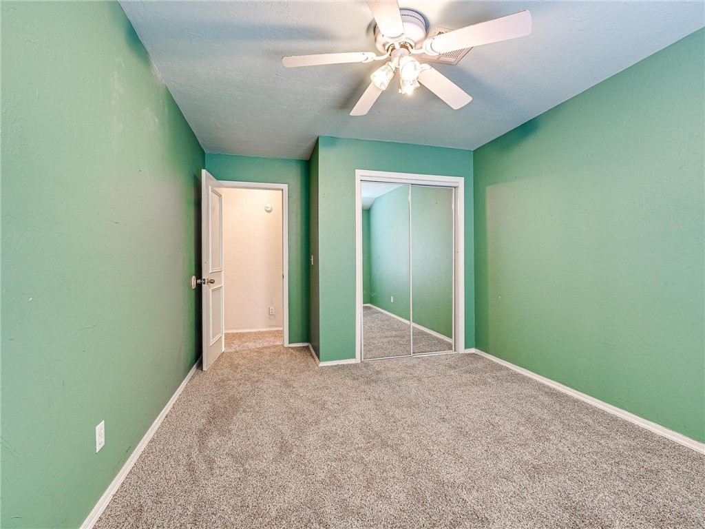 7336 N Hammond Circle, Warr Acres, OK 73132 unfurnished bedroom featuring light carpet, a closet, and ceiling fan