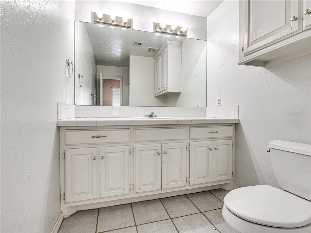7336 N Hammond Circle, Warr Acres, OK 73132 bathroom featuring tile floors, toilet, and vanity