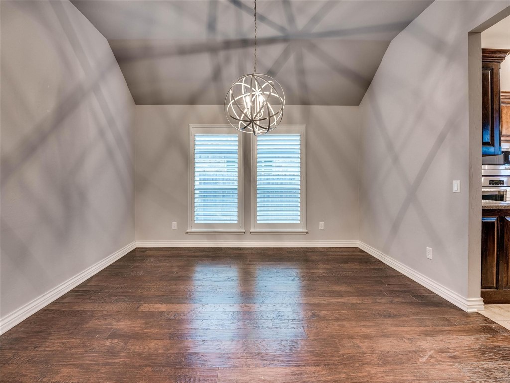 4311 Kensal Rise Place, Norman, OK 73072 spare room featuring hardwood flooring, natural light, and a notable chandelier