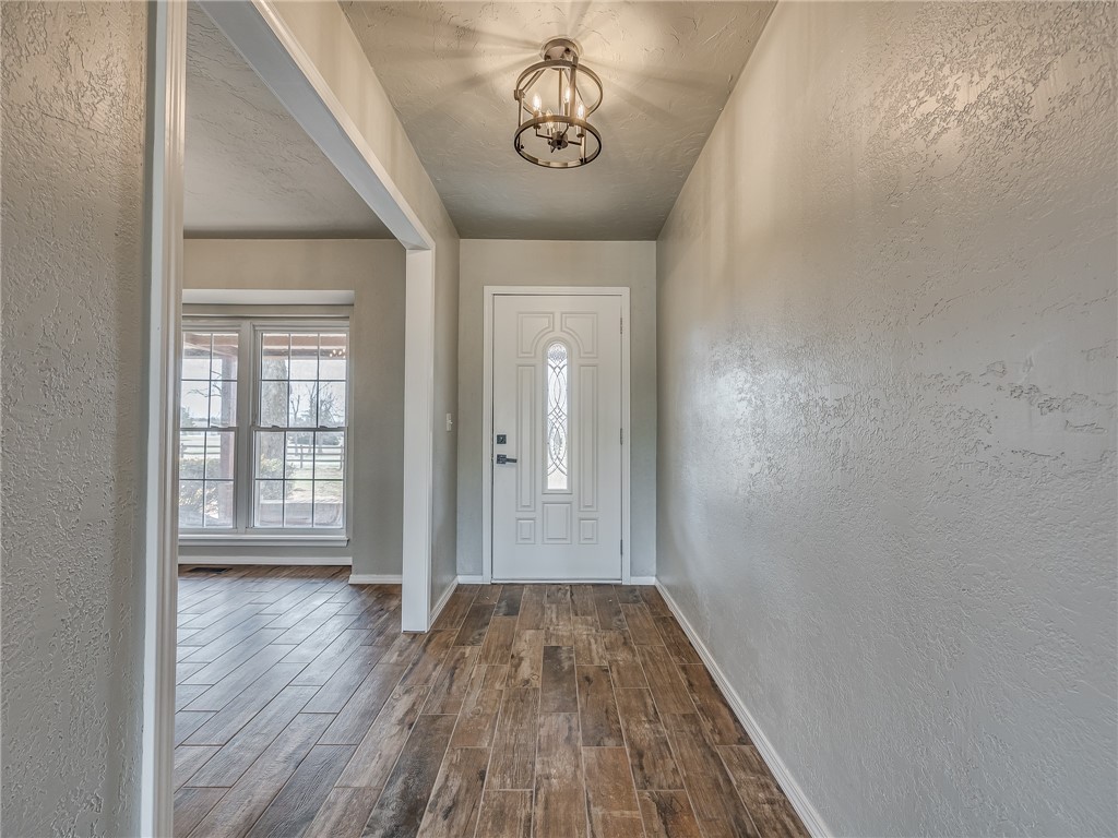 2233 W KEENS Drive, Mustang, OK 73064 entryway with dark hardwood / wood-style flooring and a notable chandelier