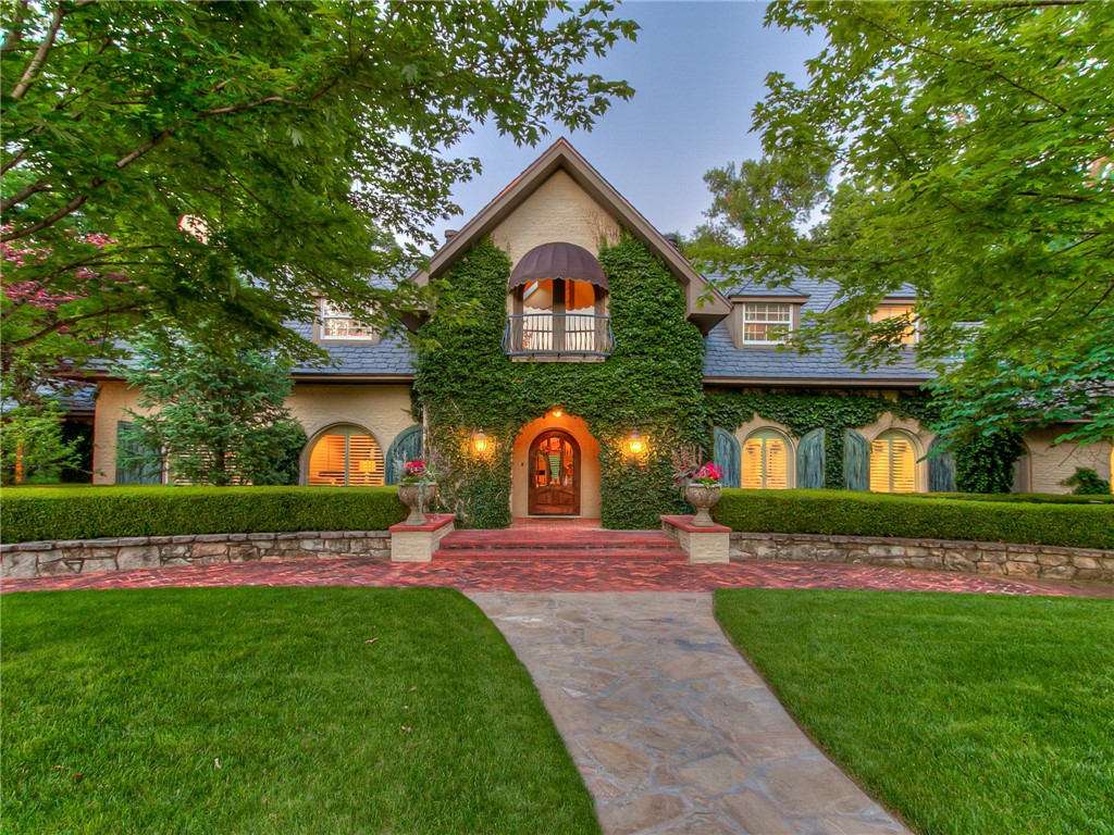 A combination of Old World charm, unique historical characteristics & traditional style, this one-of-a-kind home in a quiet neighborhood near the OU campus offers resort-style living with outdoor patios, game courts, and an incredible pool on over 2 acres surrounded by lush landscape and mature trees! The home boasts over 4,400 s.f. of living space with four ensuite bedrooms -- two up and two down. Wood floors flow throughout the downstairs. The awe-inspiring great room features 25' cathedral ceilings with beams recovered from an old schoolhouse, paneling taken from an English pub, and a floor-to-ceiling fireplace fronted with limestone from the Murrah Building. The living room fireplace mantle was sourced from the French Quarter. Large arched picture windows offer panoramic views of the grounds! The craftsmanship is phenomenal throughout, like the curved banister staircase! And to top it off this property boasts the oldest and largest tree recorded in Norman!