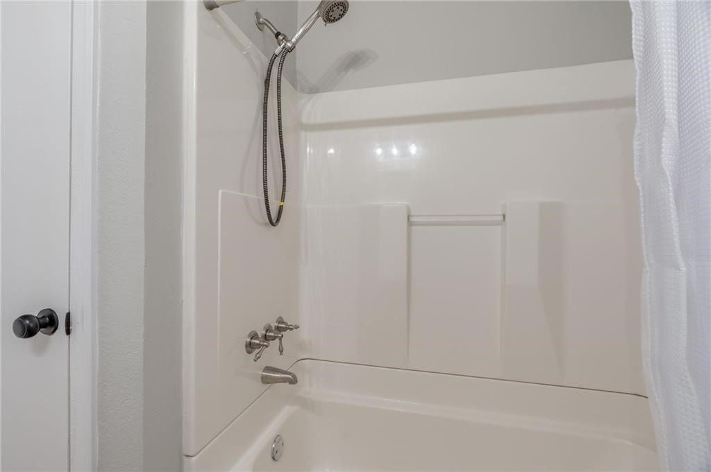 3425 NW 28th Street, Oklahoma City, OK 73107 bathroom featuring shower / bathtub combination and shower curtain