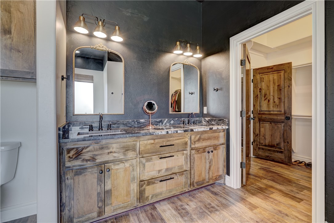 48294 Garretts Lake Road, Shawnee, OK 74804 bathroom featuring hardwood flooring, double vanities, and multiple mirrors