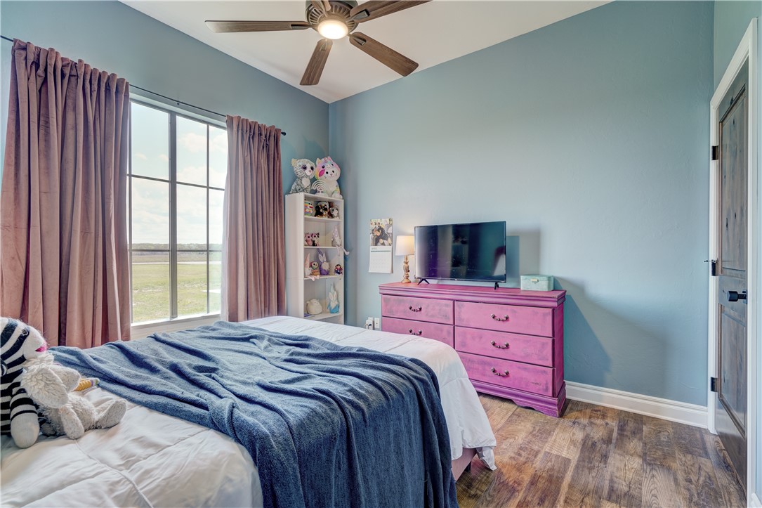 48294 Garretts Lake Road, Shawnee, OK 74804 bedroom with natural light, a ceiling fan, wood-type flooring, and TV