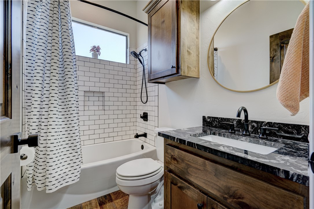 48294 Garretts Lake Road, Shawnee, OK 74804 full bathroom featuring large vanity, toilet, shower / bathtub combination, shower curtain, and mirror