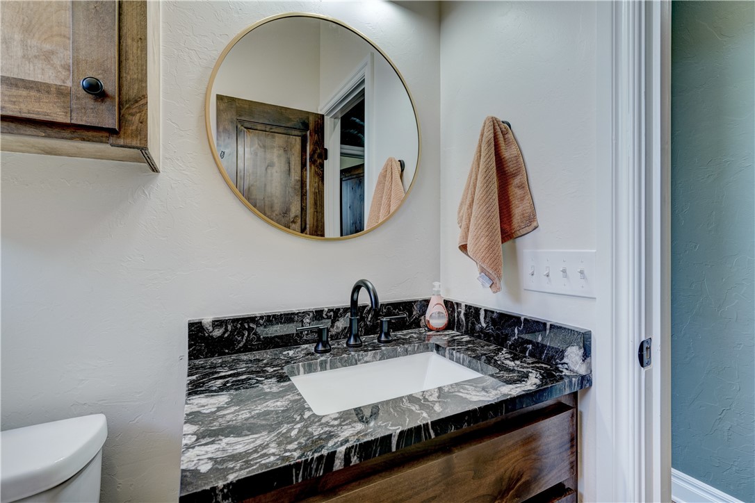 48294 Garretts Lake Road, Shawnee, OK 74804 half bath featuring mirror, toilet, and oversized vanity