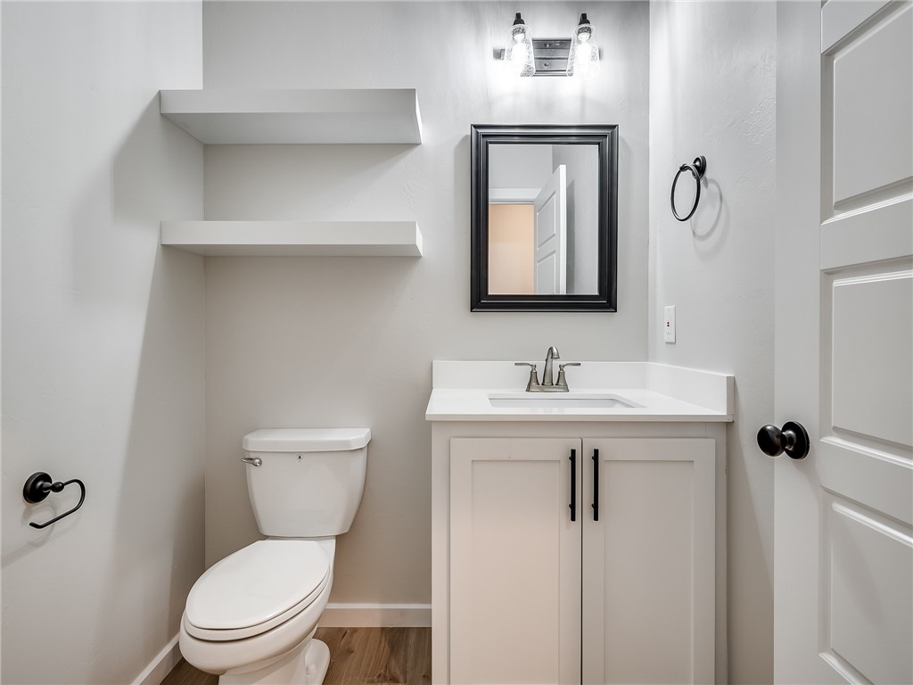 1005 Heritage Hills Drive, Tuttle, OK 73089 half bathroom featuring hardwood floors, mirror, toilet, and vanity