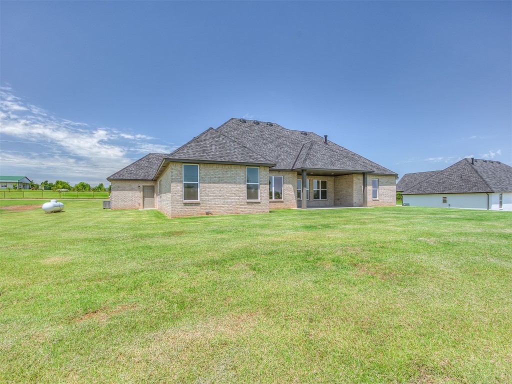 1005 Heritage Hills Drive, Tuttle, OK 73089 back of property featuring a yard