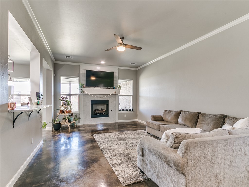 13304 Brampton Way, Yukon, OK 73099 living room featuring a fireplace, a ceiling fan, and TV