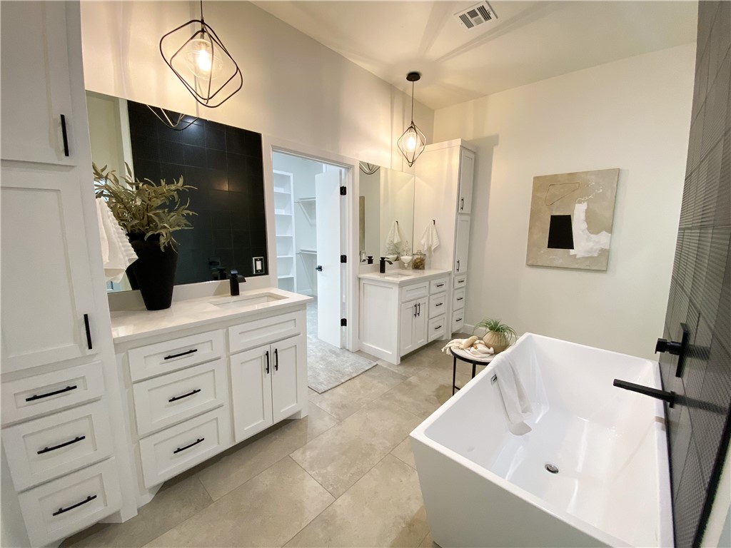 2441 SW 127th Street, Oklahoma City, OK 73170 bathroom with tile floors, a tub, mirror, and double large vanity