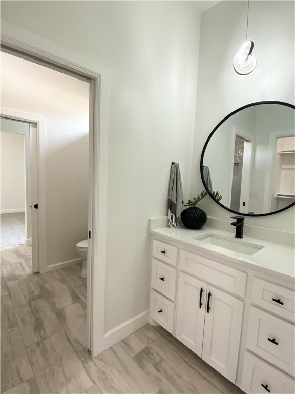 2441 SW 127th Street, Oklahoma City, OK 73170 half bathroom featuring hardwood floors, vanity, mirror, and toilet