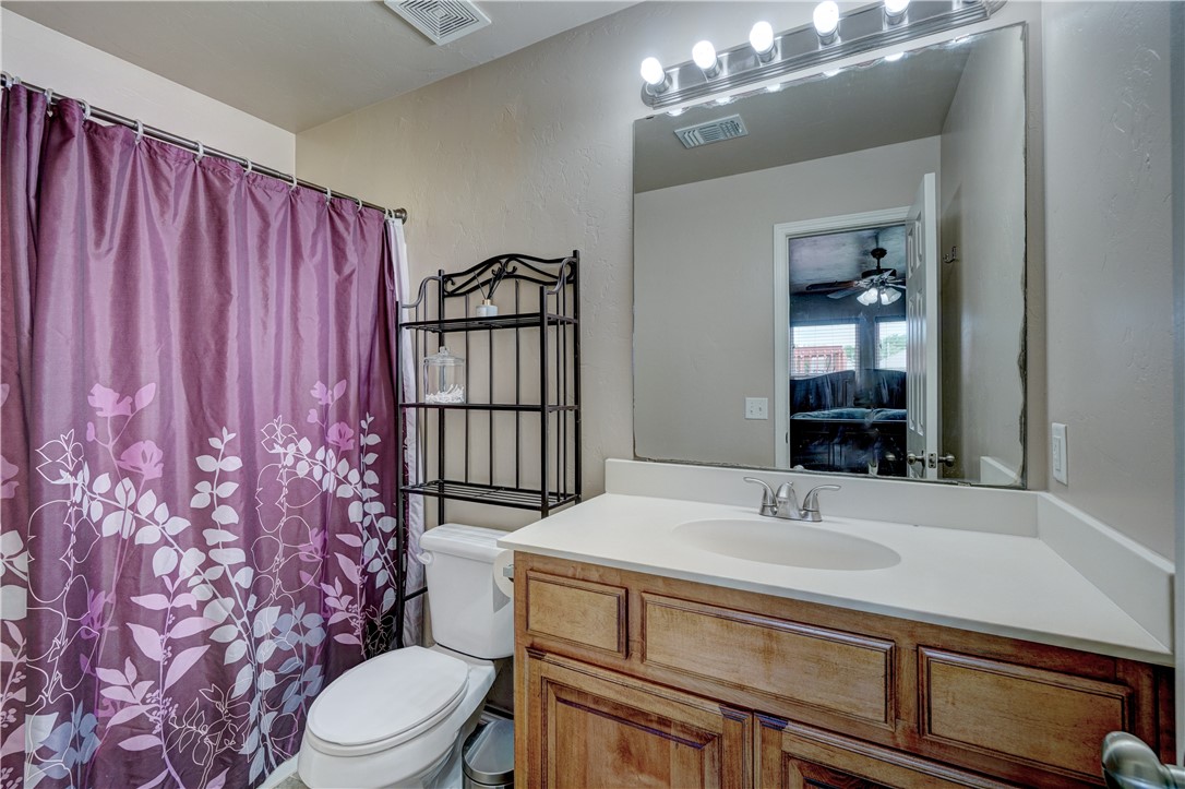 9533 SW 25th Street, Oklahoma City, OK 73128 bathroom featuring a ceiling fan, shower curtain, mirror, vanity, and toilet