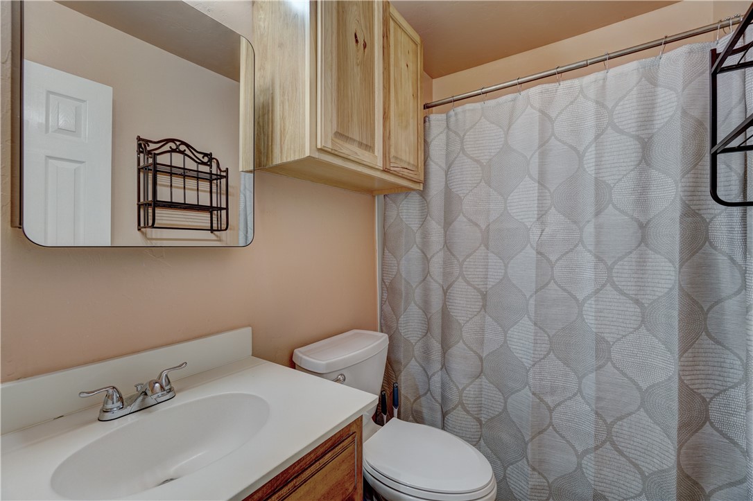 9533 SW 25th Street, Oklahoma City, OK 73128 bathroom with toilet, shower curtain, mirror, and vanity