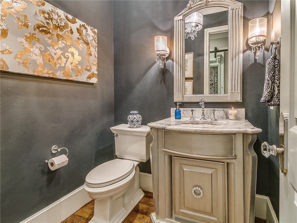 4020 NE 117th Street, Oklahoma City, OK 73131 half bath featuring hardwood flooring, toilet, mirror, and vanity