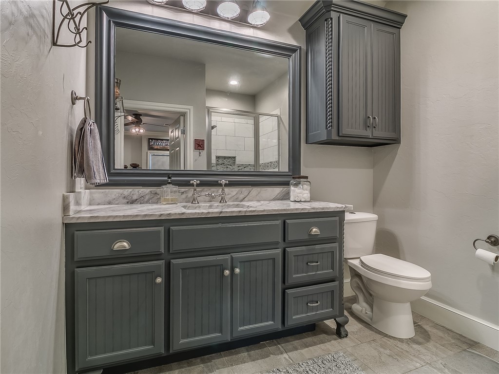 4020 NE 117th Street, Oklahoma City, OK 73131 half bathroom featuring tile flooring, vanity, toilet, and mirror