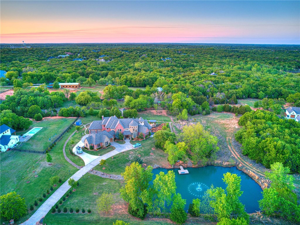 A luxurious and meticulously crafted residence nestled in the heart of Edmond within walking distance of Lake Arcadia. This stunning estate offers an impressive 5,314 square feet of living space, thoughtfully designed to capture the epitome of luxury living. As you approach the property, you will be struck by its stunning architecture, stocked pond, meticulously landscaped gardens, & gorgeous outdoor living areas. Featuring a custom Caviness pool & hot tub complete with a waterfall, a gardening area, an outdoor kitchen, and a cozy fire pit. Amenities include: game room, workout/gym room, office/study, Control 4 Home Automation, multiple outdoor living spaces, balcony views, extensive landscaping, large breakfast bar, winding staircase, Tesla charger, fire pit, large primary bedroom, water features, garden, security cameras, etc. Only 20 minutes from downtown OKC. This home offers an incredible lifestyle for those who enjoy both city living & outdoor adventures.