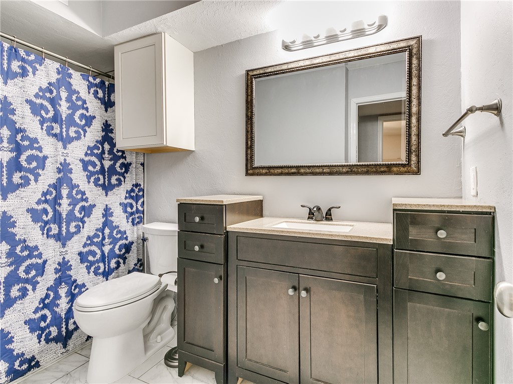 14407 N Pennsylvania Avenue, #12P, Oklahoma City, OK 73134 bathroom featuring tile floors, toilet, shower curtain, mirror, and vanity