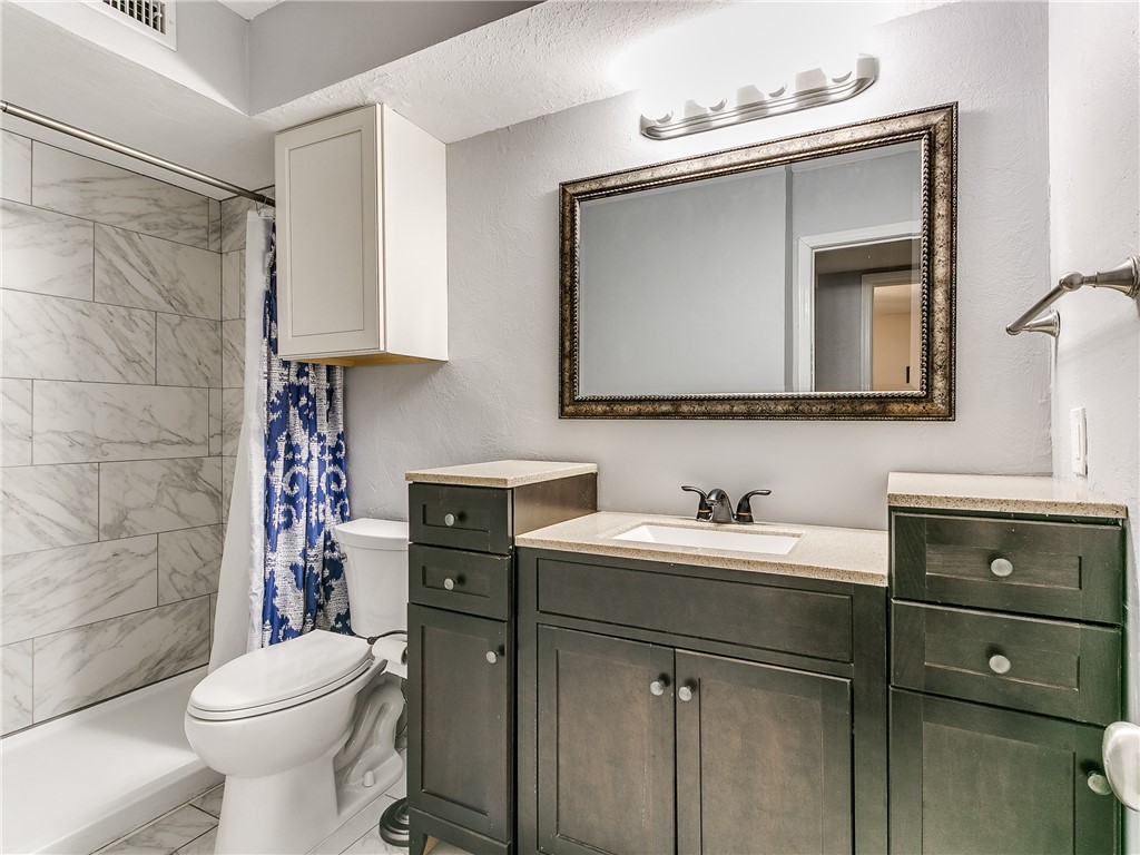 14407 N Pennsylvania Avenue, #12P, Oklahoma City, OK 73134 bathroom featuring tile floors, a shower, oversized vanity, mirror, toilet, and shower curtain