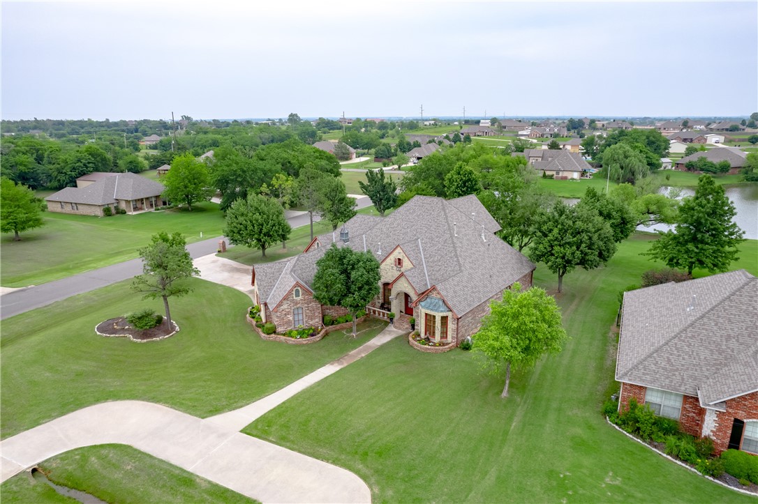 CUSTOM built, 4 bedroom, WATERFRONT, one owner home in a GATED community with access to all parts of the Oklahoma City Metro & Tinker AFB. The owners spared no expense or attention to detail when designing the home and making the views from the back patio and balcony ones that will make you not want to leave. This home has 3 bedrooms downstairs, including the master with an amazing bath and closet fit for a queen. The two secondary bedrooms share a Jack & Jill Bath with their own vanity areas. The 4th bedroom is up with the bonus room, full bath, balcony overlooking the lake, and a cozy fireplace. The bonus room has an area built-in for a gaming/poker table, a wet bar, and an area large enough for today's media room chairs and equipment. The kitchen offers a 6 burner gas cooktop with exterior ventilation, built-in dbl ovens, an extra large island with veggie sink & built in microwave & a pantry with a "Harry Potter" closet for the kids to read. This home won't disappoint.