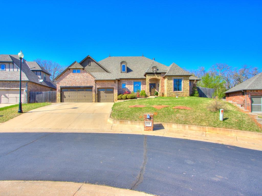 Stunning custom home in a gated community with easy I-35 access and Arcadia Lake. Enter through the front door to find a vaulted ceiling with beams and large windows overlooking the covered patio. The living room features a floor-to-ceiling stack rock fireplace, perfect for cozy winter evenings. The open floor plan is ideal for entertaining, including a spacious kitchen with abundant storage, granite countertops, a copper sink, a large pantry, and a dining area with ample seating. A mudroom and half bath are conveniently located off the garage. The main bedroom offers patio access and a luxurious bathroom with a walk-in closet, double vanity, shower, soaker tub, fireplace, TV, and ceiling fan. Additional features include a formal dining room, office, storm shelter, solar board decking, TV component closet, smart sprinkler system, smart light switches, wired speakers, tankless water heater, and an alarm system with 5 security cameras. This is truly a custom home masterpiece.