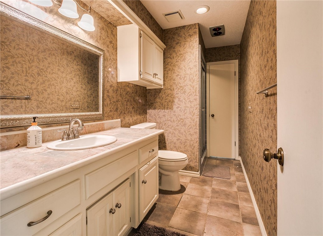 3815 Marked Tree Drive, Edmond, OK 73013 half bathroom with tile floors, toilet, mirror, and vanity
