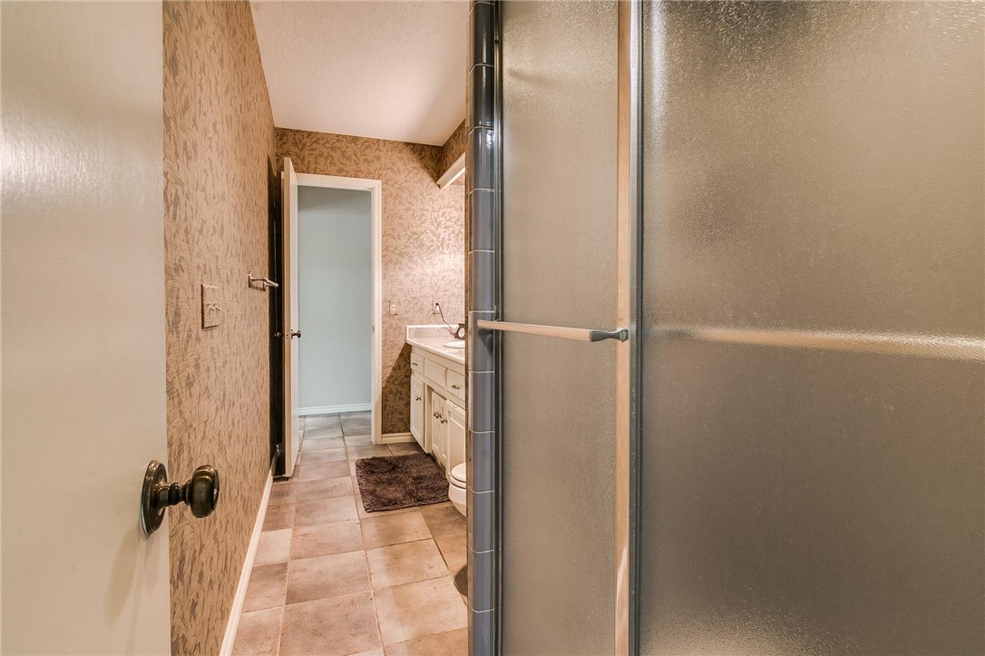 3815 Marked Tree Drive, Edmond, OK 73013 full bathroom featuring tile flooring, toilet, vanity, and shower booth