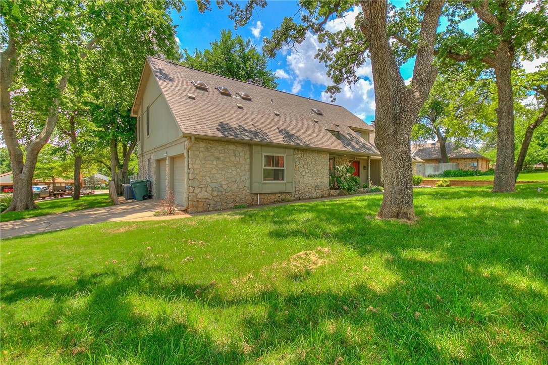 3815 Marked Tree Drive, Edmond, OK 73013 back of house featuring a lawn and central AC