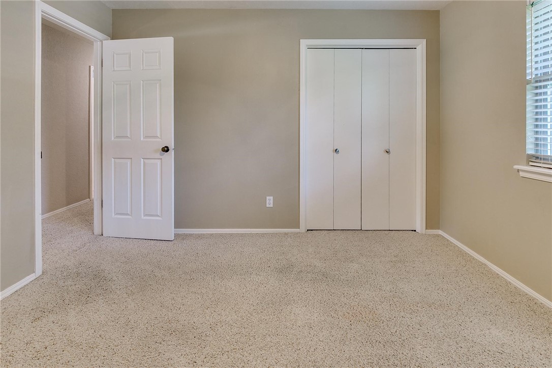 3815 Marked Tree Drive, Edmond, OK 73013 carpeted bedroom with natural light