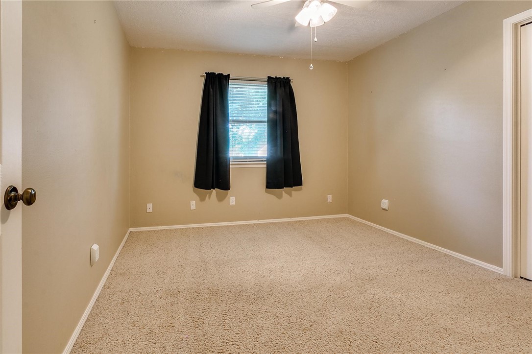 3815 Marked Tree Drive, Edmond, OK 73013 carpeted spare room featuring a ceiling fan and natural light