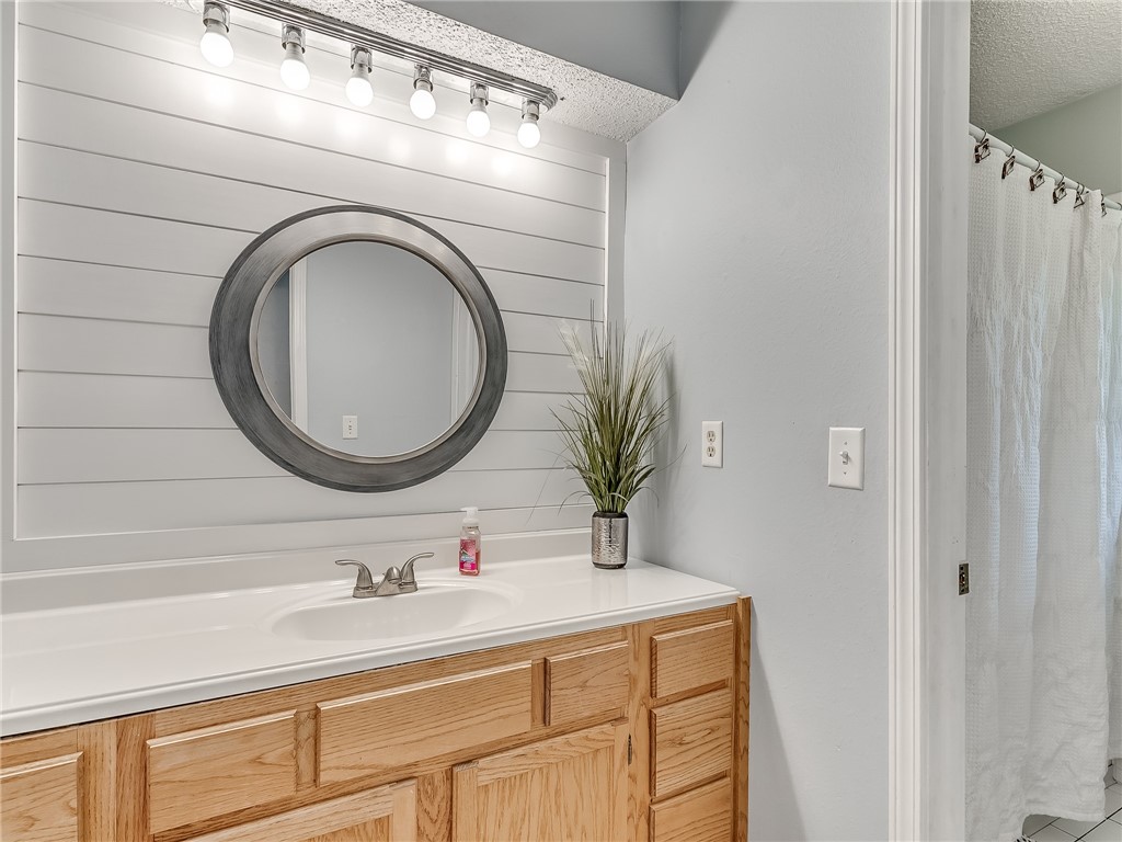 8909 Kenny Circle, Oklahoma City, OK 73132 bathroom featuring shower curtain, mirror, and vanity