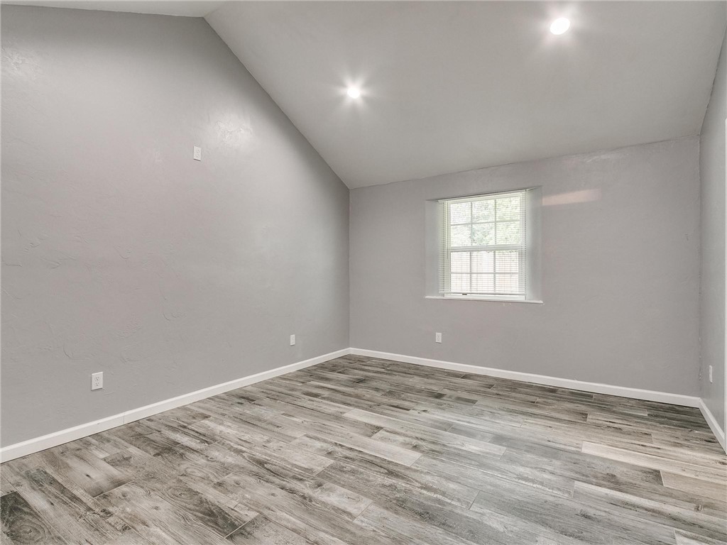 2115 N Jordan Avenue, Oklahoma City, OK 73111 wood floored empty room with lofted ceiling and natural light