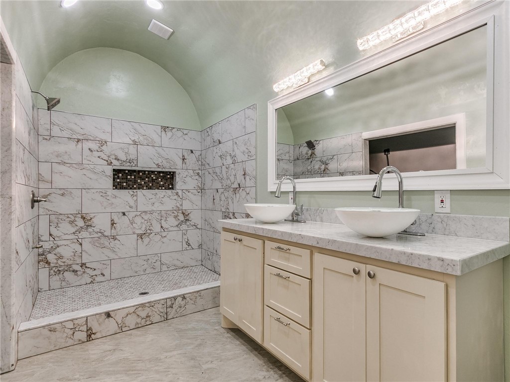2115 N Jordan Avenue, Oklahoma City, OK 73111 bathroom featuring tile floors, multiple mirrors, his and hers vanity, and a shower