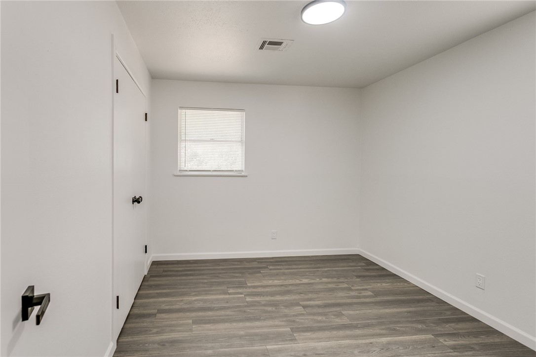 3029 S Madole Boulevard, Oklahoma City, OK 73159 wood floored empty room featuring natural light