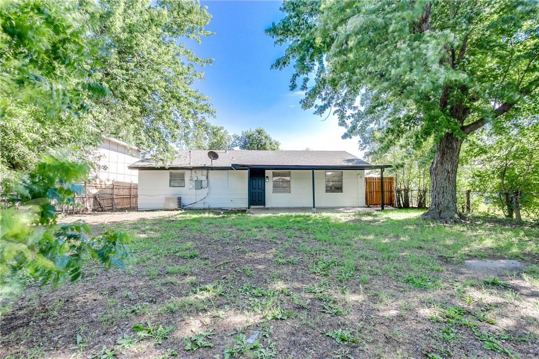 3029 S Madole Boulevard, Oklahoma City, OK 73159 back of house featuring a yard