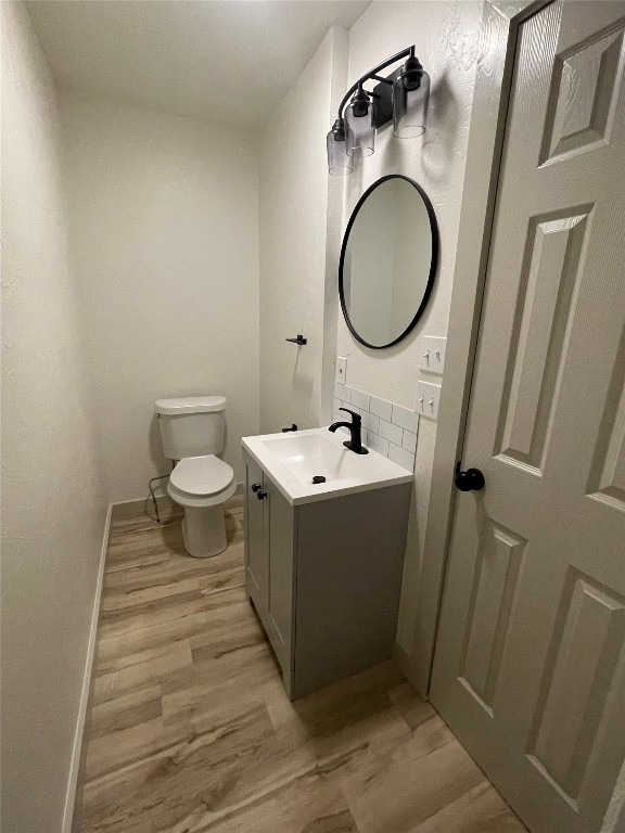 1408 N Elm Street, Guthrie, OK 73044 half bath with vanity, toilet, and mirror